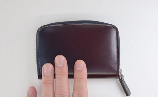 ユニコーン　コードバン財布「ミドルウォレット（アトモスフィア）」　外装の革の手触りを確認している写真