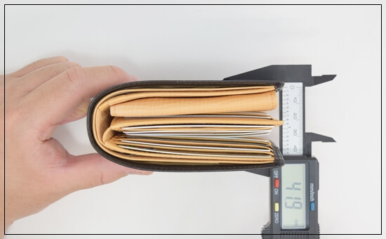 シラサギレザー二つ折り財布(ベロ付)にカード等を入れ、厚さを測った写真